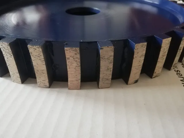 Close-up side view of a blue diamond wheel with segments